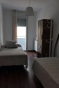 a bedroom with two beds and a dresser and a window at Apartament Ramon a Pobla in La Pobla de Segur