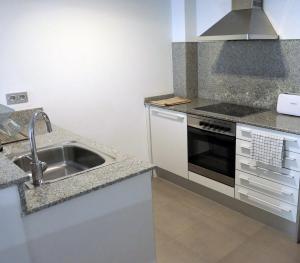 a kitchen with a sink and a stove at Apartament Ramon a Pobla in La Pobla de Segur +7 photos