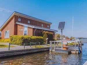 um edifício com um painel solar junto à água em Het Kraaijennest Miva em Uitgeest