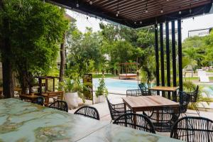 a patio with tables and chairs and a pool at Central Park ModernStudio, Gym, Spa, Wi-Fi, cowork in Tulum