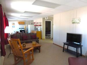White Caps Motel في بورت كلينتون: غرفة معيشة مع أريكة وتلفزيون