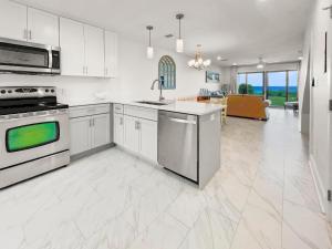 a kitchen with white cabinets and a stove top oven at Seacrest - 6 Townhouse in Watersound Beach