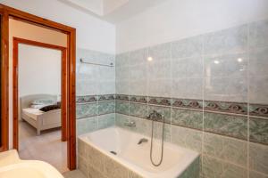 y baño con bañera y ducha con espejo. en ISTORIA Residence en Stavros