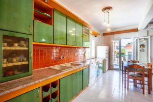 a kitchen with green cabinets and a sink at ISTORIA Residence in Stavros