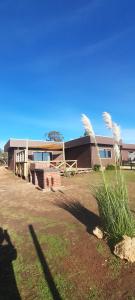 a building with a fence and grass in front of it at 7 Olas lodge in Algarrobo