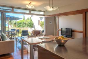a living room with a table and a television at The Sands Apartment 23 in Onetangi