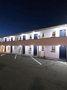 een groot wit gebouw met blauwe ramen in de nacht bij Budget Inn Motel Suites Somers Point in Somers Point