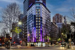un edificio alto con iluminación púrpura en una calle de la ciudad en Club Wyndham Sydney, Trademark Collection by Wyndham en Sídney