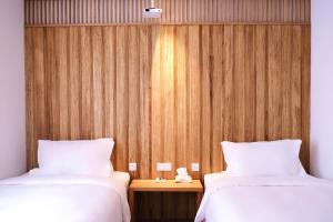 two beds in a room with a wooden wall at Hantang Inn Hostel Xi'an in Xi'an