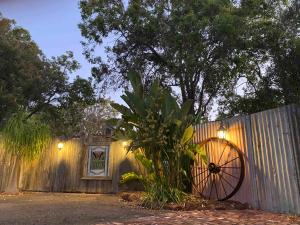 una valla de madera con una rueda de madera junto a una planta en Gypsy Van Tiny House with Unique Outdoor Bathroom, WIFI & Firepit, en Coodanup