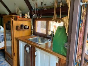 a kitchen with a sink and a window in an rv at Gypsy Van Tiny House with Unique Outdoor Bathroom, WIFI & Firepit in Coodanup