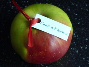 una mela con un cartello che dice "sentirsi a casa". di Feel at home - Old Town a Danzica