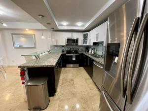 a kitchen with a refrigerator and a counter top at Breathtaking ocean view! 15th floor in Miami Beach