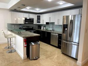 cocina con armarios blancos y nevera de acero inoxidable en Breathtaking ocean view! 15th floor, en Miami Beach