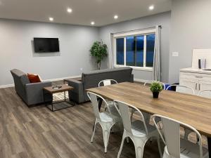 sala de estar con mesa, sillas y sofá en Thistle Ridge (Lower) New Waterton Lakes Area Waterfront Home en Mountain View
