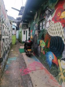 a wall covered in graffiti with a motorcycle parked next to it at Hostal Gastro Bar Casa Colibrí in Bogotá