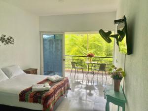 a bedroom with a bed and a table with chairs at Ikara Hotel Campestre Villeta in Villeta