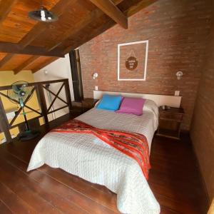 Posto letto in camera con muro di mattoni di Cabañas Canluma a Villa Giardino