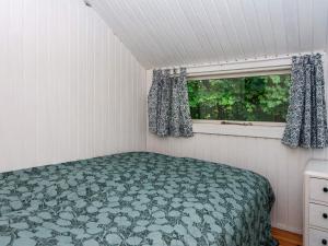 um pequeno quarto com uma cama e uma janela em Holiday home Knebel LII em Knebel