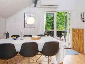 uma sala de jantar com uma mesa branca e cadeiras em Holiday home Knebel LII em Knebel