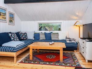 uma sala de estar com um sofá azul e uma mesa em Holiday home Knebel LII em Knebel