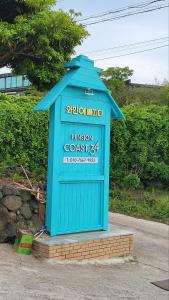 a blue building with a sign for a prison costs at Aewol Coast 34 in Jeju