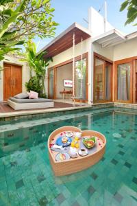 a swimming pool with a toy in the middle of a house at The Jimbaran Villa by Ini Vie Hospitality in Jimbaran