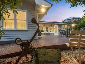 a house with a large deck with a bench and umbrella at The Buoys in Blairgowrie