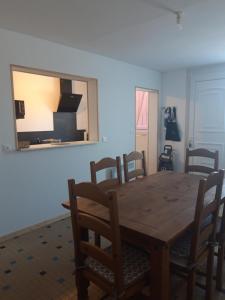 mesa de comedor con sillas y espejo en la pared en Maison individuelle draps et serviettes non inclus, en Morcenx