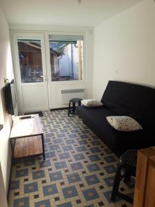 een woonkamer met een bank en een tafel bij Maison individuelle draps et serviettes non inclus in Morcenx