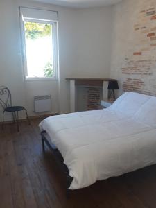 1 dormitorio con cama blanca y ventana en Maison individuelle draps et serviettes non inclus, en Morcenx