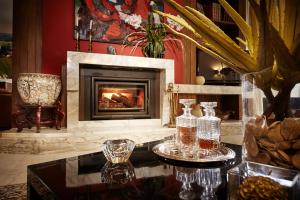 a living room with a fireplace and a table with glasses at La Dimora Del Bassotto in San Giuliano Terme