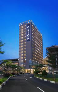 un grand bâtiment avec un panneau sur son côté dans l'établissement ASTON Nagoya City Hotel, à Batam Center