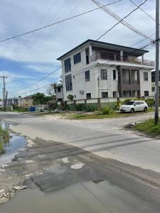 an empty street in front of a white building at APEX BOUTIQUE APARTMENTS in Georgetown