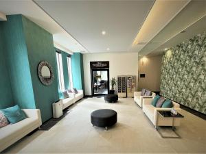 a lobby with a waiting room with couches and a stool at Green Rich Hotel & Capsule Naha - Artificial hot spring Futamata Yunohana in Naha