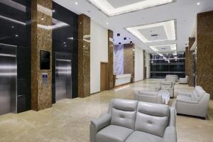 a lobby with chairs and tables in a building at ASTON Nagoya City Hotel in Batam Center