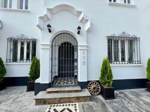 a front door of a white house with a black gate at WasiPai Boutique Hotel in Lima