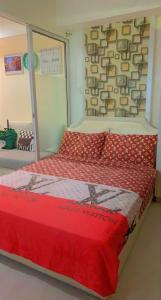 a bedroom with a bed with a red comforter at Azure Urban Resort in Manila