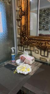 un baño con encimera con lavabo con flores y espejo en Azure Urban Resort, en Manila