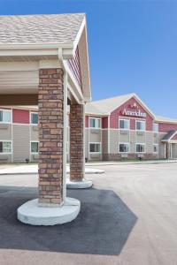 un edificio con dos columnas de ladrillo en un estacionamiento en AmericInn by Wyndham Hawley, en Hawley