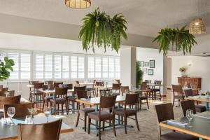 a restaurant with tables and chairs and windows at ibis Styles Tamworth in Tamworth