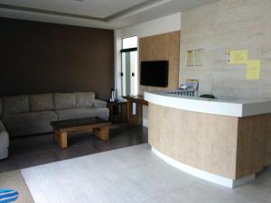 ein Wohnzimmer mit einem Sofa und eine Küche mit einer Theke in der Unterkunft Hotel Mundial in Itabuna