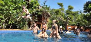 a group of people sitting in a swimming pool at Habarana Tree house Mutu village in Habarana