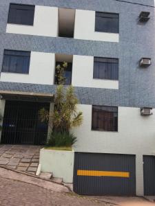 un edificio de apartamentos con una palmera delante en Hotel Mundial en Itabuna