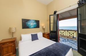Un pat sau paturi într-o cameră la Anchorage Seafront Hotel