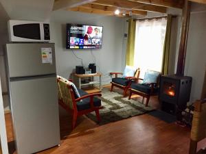 a living room with a refrigerator and a stove at Villa La Quimera in Nevados de Chillan