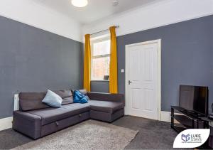 a living room with a couch and a tv at Luke Stays - Brandling Street in Monkwearmouth