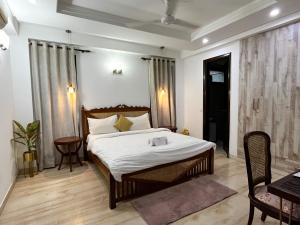 ニューデリーにあるAvatar Living @Safdarjung Enclaveのベッドルーム1室(ベッド1台、テーブル、椅子付)