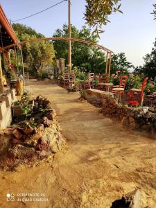 a patio with red chairs and tables in a garden at Lavillafortuna 