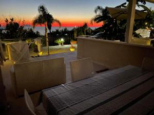 a patio with a table and chairs and a sunset at L'Aurora Tropea in Torre Marino